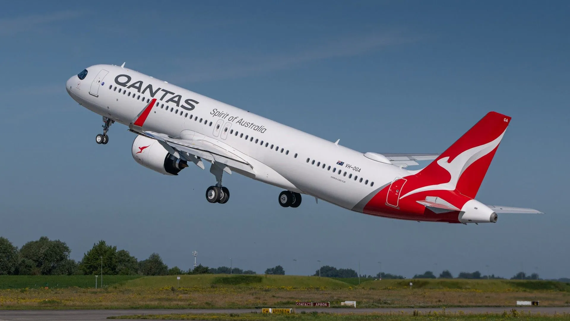 Qantas airliner taking off from runway, white fuselage with large 'QANTAS' logo and red tail fin with kangaroo mark.