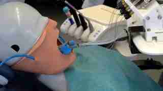 An anesthesia training mannequin with an endotracheal tube connected to a ventilator and monitoring equipment on a clinical setup